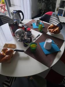 a table with bread and a plate of food on it at la conviviale in Bénouville