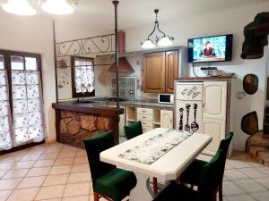 a kitchen with a white table and a white refrigerator at two-room apartment with parking space in Rio nellʼElba