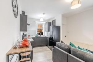 een woonkamer met een bank en een keuken bij Small, Cosy 2BR 1Bathroom Nearby the Town Center in Brechin
