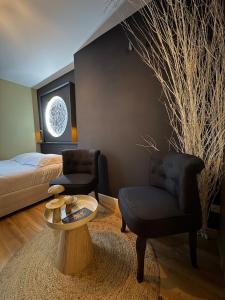 Un dormitorio con una cama, una mesa y una silla. en Votre expérience insolite - Clair de lune, en Caen