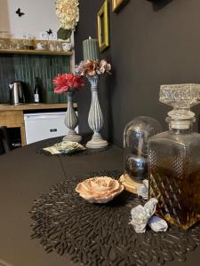 una mesa con jarrones y un frasco de cristal con flores. en Votre expérience insolite - Clair de lune, en Caen