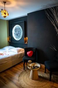 Un dormitorio con una cama, una silla y una mesa. en Votre expérience insolite - Clair de lune, en Caen 13 fotos más