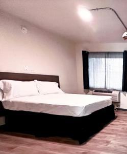 Postel nebo postele na pokoji v ubytování Studio City Suites, a Travelodge by Wyndham