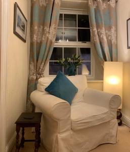 a living room with a white couch and a window at Evangelisa in Lampeter +3 photos