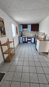 a large kitchen with blue cabinets and a tiled floor at Haus Alegria mit Traumblick in Peniscola +20 photos