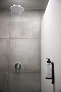 a bathroom with a shower with a soap dispenser at KY Mountain Hostel Arinsal in Arinsal