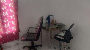 a small table with two chairs and a table with at Homestay syariah off in Karawang +4 photos