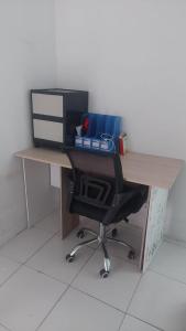 a desk with a computer monitor and a chair at Homestay syariah off in Karawang