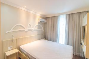 une chambre avec un grand lit blanc avec une fenêtre dans l'établissement Hotel Mercure, à Brasilia 14 autres photos