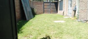 a backyard with a door and a grass yard at Alquiler por día para turismo in General Alvear