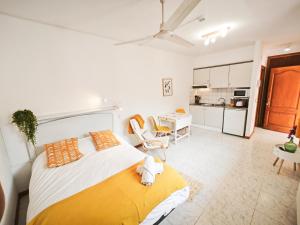 a bedroom with a large bed and a kitchen at El Penell Estudi Mestral in Vilamaniscle