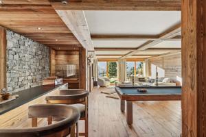 - un billard dans une pièce dotée d'un mur en pierre dans l'établissement Vista Alpina by Mrs Miggins, à Crans-Montana