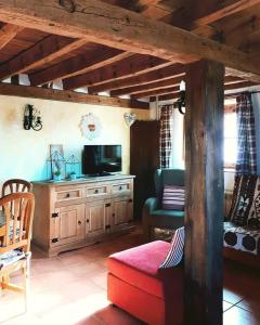 un salon avec un canapé et une télévision dans l'établissement Anticca Rural hasta 11 personas, à Atauta