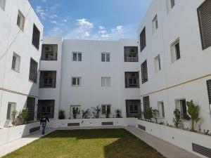 a person walking in front of a large white building at Very high standing apartment in Gammarth