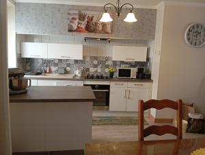 a kitchen with white cabinets and a counter top at Villa Laurence in Lézignan-Corbières +4 photos