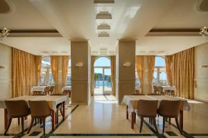 a dining room with tables and chairs and windows at BO Hotel Palazzo in Poreč