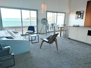 a living room with a couch and chairs and a kitchen at Royal Antibes - Luxury Hotel, Résidence, Beach & Spa in Antibes