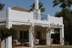 San RoqueにあるVilla Destenyのヤシの木が植わる白い家