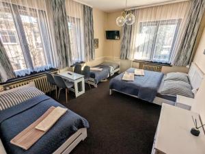 a hotel room with two beds and a table at Hotel Alfa in Trutnov