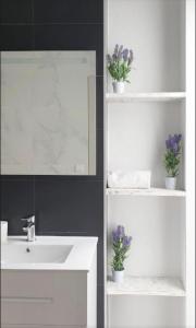 a white bathroom with a sink and a mirror at Olivia Apartments TRG in Benidorm