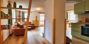 a living room with a kitchen and a living room with a couch at Ferienwohnung Villa Oben im Sandsteinidyll in Rathen +15 photos