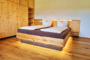 a bedroom with a wooden bed with white pillows at Ferienwohnung Villa Oben im Sandsteinidyll in Rathen