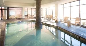 a pool with chairs and a palm tree in a building at Holiday Inn Express & Suites Oklahoma City Downtown - Bricktown by IHG in Oklahoma City