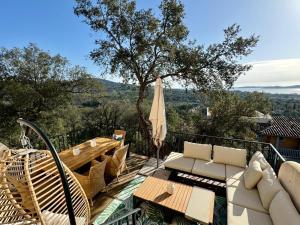 a patio with a table and chairs and an umbrella at Les Restanques du Golfe de Saint Tropez Außergewöhnlicher Meerblick TOP WLAN in Grimaud