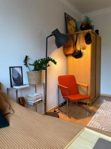 a bedroom with a bed and a red chair and a lamp at Cozy studio apartment with amazing location in Helsinki