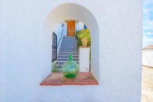 a green glass vase sitting on a wall with stairs at Casa Jardin Del Olivar Für 18 Personen in Alcaucín
