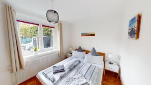 une chambre blanche avec un lit et une fenêtre dans l'établissement Eifel Oase, à Monschau