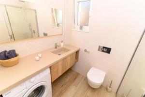 une salle de bain avec un lavabo et une machine à laver dans l'établissement Hygge Boutique Apartment, à Trogir
