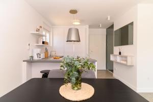 un vase de fleurs assis sur une table dans une cuisine dans l'établissement Hygge Boutique Apartment, à Trogir 32 autres photos