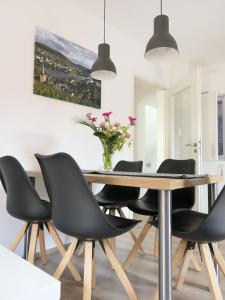a dining room with a wooden table and black chairs at Haus Budinger in Alf