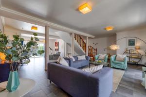 a living room with blue couches and a table at Villa Casa Branca in Ribamar