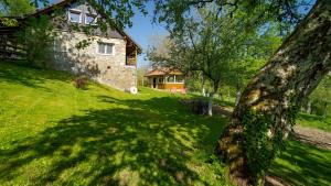 a house on a grassy hill with a tree at Holiday Home Sleme in Zrnovac
