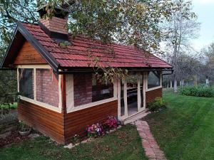 a small house with a red roof in a yard at Holiday Home Sleme in Zrnovac