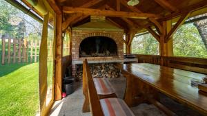 a wooden pavilion with a fireplace in a yard at Holiday Home Sleme in Zrnovac +22 photos