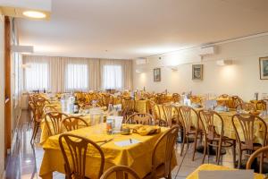 a room filled with tables and chairs with yellow table cloth at Hotel Careni Villa Italia in Finale Ligure +67 photos