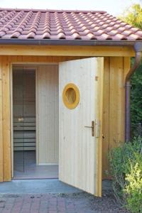 ein Haus mit einer Tür davor in der Unterkunft Maisonette Seegang - eingezäuntes Grundstück mit Seeblick in Flessenow