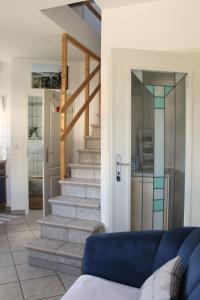 a living room with stairs and a blue couch at Gemütliche Maisonette Wohnung Seelenblick in Berndorf +16 photos