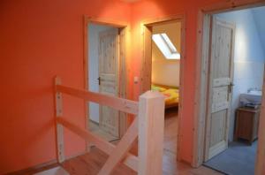 Habitación con paredes de color naranja, escalera y dormitorio. en Ferienhaus Haus Bärenstein In Naundorf Mit Grill, Terrasse, Sauna Und Kaminofen, en Struppen