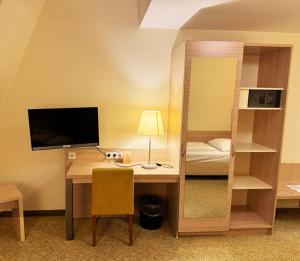 a room with a desk and a bed and a room with a computer at Parkhotel Green Garden in Bad Hersfeld