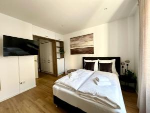 a bedroom with a large white bed and a flat screen tv at Spiritus Apartments in Augsburg +4 photos