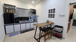 a kitchen with a wooden table and a counter at Pontian Homestay - 181 Homestay MusIim Friendly in Kampong Atap