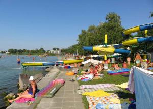 a group of people sitting on the grass near the water at Holiday home in Siofok - Balaton 52077 in Siófok