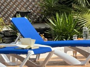 niebiesko-białe krzesło z książką w obiekcie Villa Adel 56, private heated pool, parking w mieście Playa Blanca