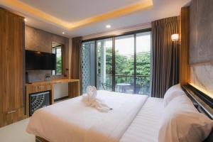a hotel room with a large bed and a balcony at The Mantra Hotel Kata Noi in Kata Beach