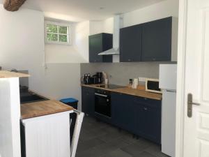 a kitchen with blue cabinets and a counter top at La Guyomarais - Gîte Terre in Saint-Denoual
