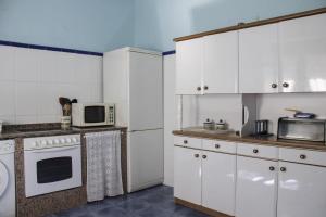 a kitchen with white cabinets and a microwave at Balcon del Alba VUT N1238 in Lastres